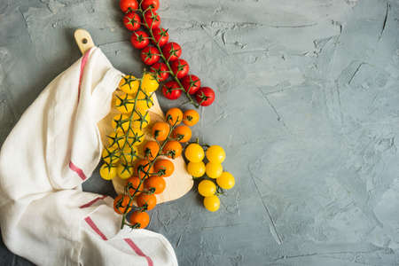Organic cherry tomato on rustic concrete background with copy space