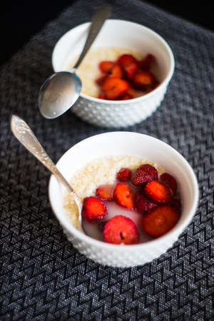Healthy breakfast concept with oatmeal and strawberries on rustic background with copy spaceの写真素材