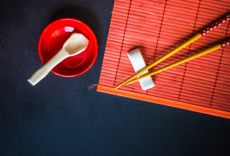 Table setting in red color for asian cuisine dinner with chopsticksの写真素材