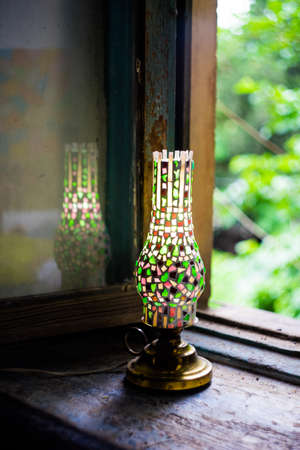 Mosaic elements of rustic lamp on wooden background opened window in old houseの写真素材