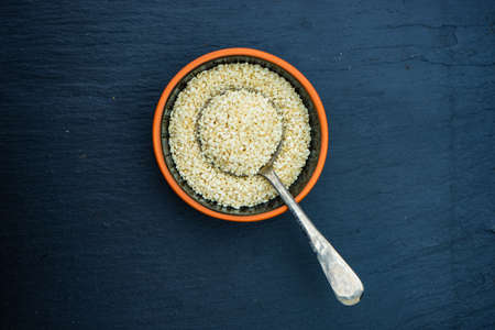 Organic superfood ingredient sesame seeds on black background with copy space