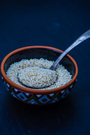Organic superfood ingredient sesame seeds on black background with copy spaceの写真素材