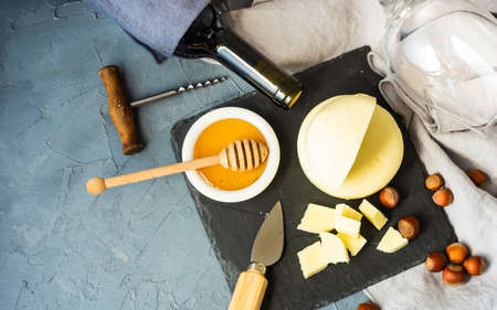 Cheese concept with famous georgian suluguni cheese in saperavi wine with fruits and spices on rustic backgroundの写真素材