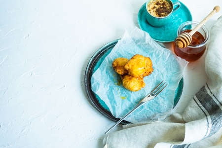 Homemade honey donuts on ceramic plate with honey and orange juice as a breakfast conceptの写真素材
