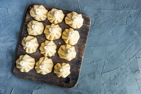 Famous georgian dish meat khinkali uncooked on cutting board with copy spaceの写真素材