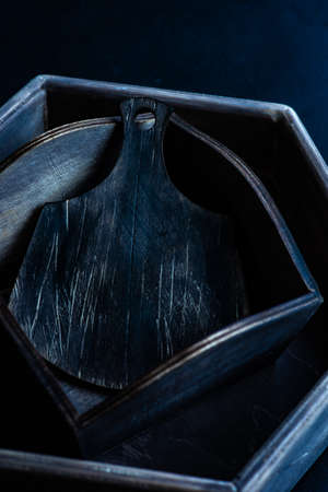 Old wooden boxes and cutting board on vintage dark wooden tableの写真素材