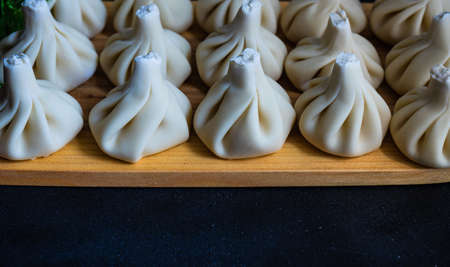 Famous georgian dish meat khinkali uncooked on cutting board with copy spaceの写真素材