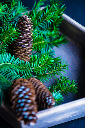Christmas holiday concept with wooden box full of festive decor on dark backgroundの写真素材