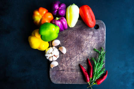 Organic food concept with fresh different colors bell peppers on rustic background with copy spaceの写真素材