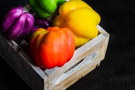 Organic food concept with fresh different colors bell peppers on rustic background with copy space
