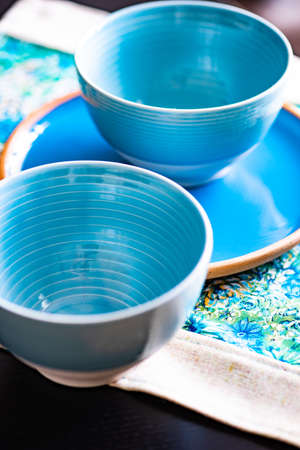 Rustic table setting with bright blue floral napkin on white table with copy space