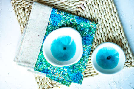 Rustic table setting with bright blue floral napkin on white table with copy space