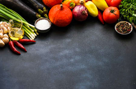 Frame with organic fresh vegetables like eggplant, tomato, herbs etc on rustic background with copy spaceの写真素材
