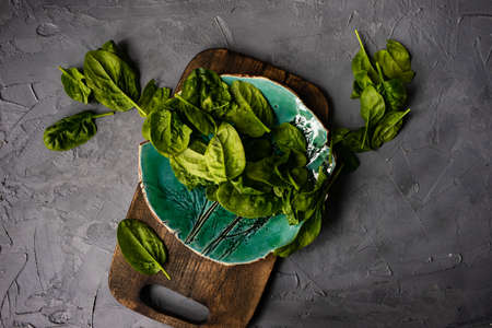 Fresh organic leaves of baby spinach on rustic background with copy space as a organic food conceptの写真素材
