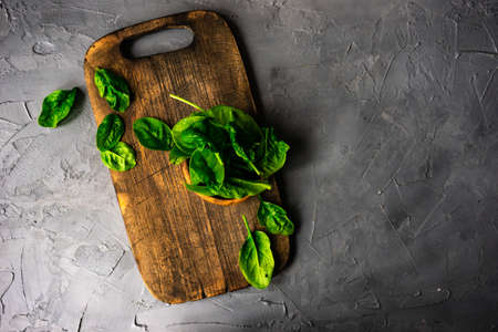 Fresh organic leaves of baby spinach on rustic background with copy space as a organic food conceptの写真素材