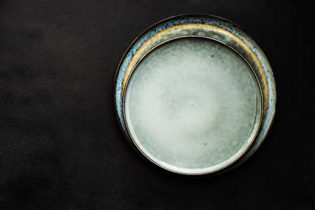 Ceramic plate on black wooden table with copy spaceの写真素材