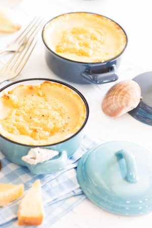 Seafood concet with mussels and cheese in bowl on white concrete background with copy space