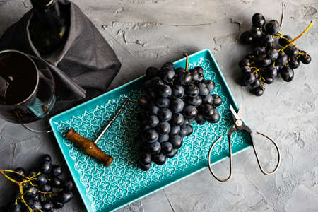 Different grapes and red wine on rustic background with copy space