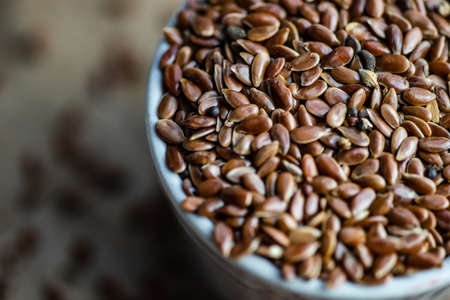 Organic food concept with flax seeds in a ceramic bowl on a table with copy spaceの写真素材
