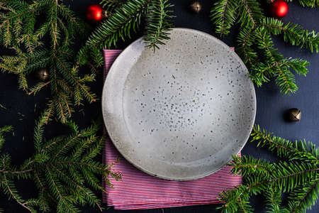 Festive table setting with ceramic plate and holiday decor on wooden background with copy spaceの写真素材