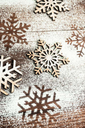 Christmas card concept with snow flakes on vintage wooden backgroundの写真素材