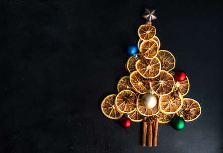Christmas holiday concept with oranges and cinnamon  shaped in Christmas tree on dark wooden backgroundの写真素材
