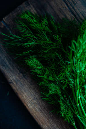 Organic food concept with fresh dill herb on cutting board