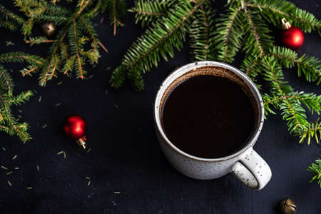 Cup of coffee on dark wooden background with holiday decor and copy spaceの写真素材
