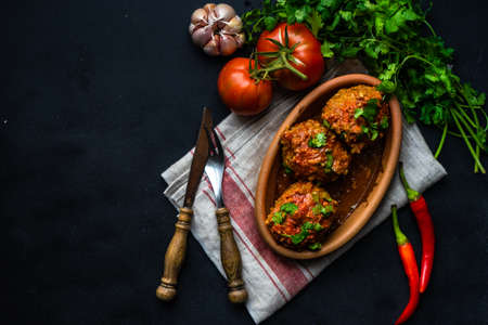 Meatballs in spicy tomato sauce with coriander and garlic on rustic table
