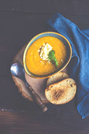Autumnal food concept with bowl of tasty cream soup on rustic background with copy spaceの写真素材