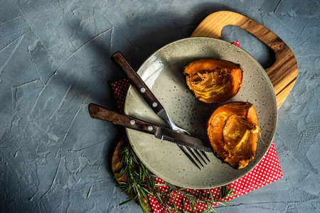 Baked pumpkin slice with rosemary on plate with copy spaceの写真素材