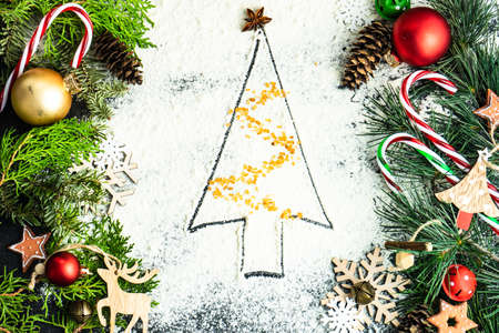 Christmas card with xmas tree made with flour on dark backgroundの写真素材