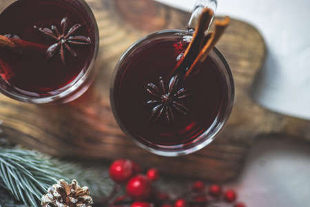 Traditional winter drink  mulled wine and Christmas decorations on white rustic background