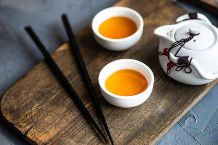 Teapot and cupd with tea on rustic background