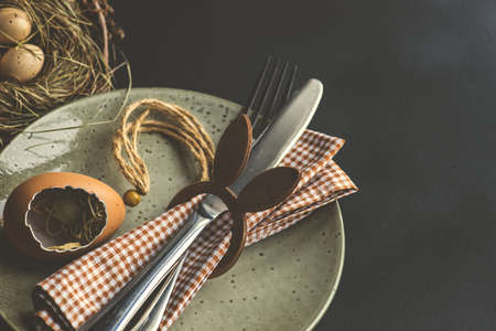 Festive easter table setting with colored eggs and easter bunny concept with copyspace