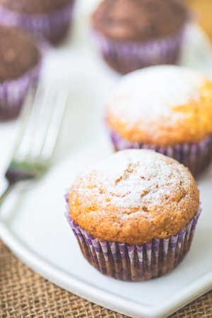 Tasty lemon and chocolate cupcakes in rustic interior