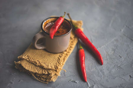 Vintage ceramic cup of hot spicy  chocolate with red pepper, selective focus