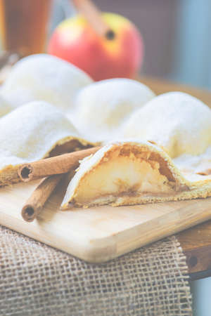 Apple cake dessert with cinnamon sticks and cup of tea with lemonの写真素材