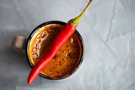 Vintage ceramic cup of hot spicy  chocolate with red pepper, selective focus