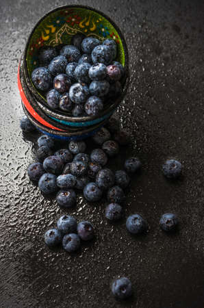 Ripe organic bilberries on dark wooden table with copyspace as a organic food conceptの写真素材