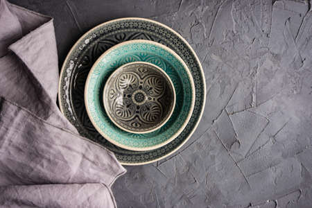 Table set with different size eastern style plates on concrete background with copy space