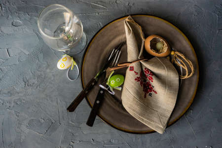 Table setting for festive Easter dinner on rustic background with copy space