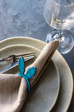 Table setting for festive Easter dinner on rustic background with copy space