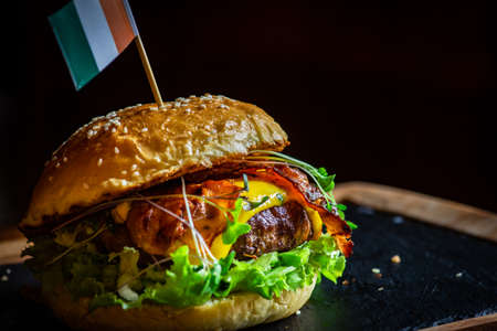 Close up of Irish hamburger with meat, vegetables and bacon on rustic background with copy spaceの写真素材