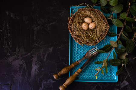 Table setting for festive Easter dinner on rustic background with copy space