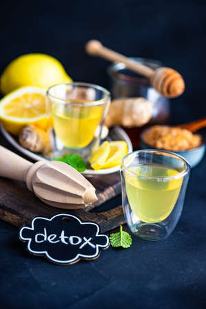 Detox drink with organic lemon, ginger and mint on dark background with copy spaceの写真素材