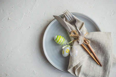 Festive table setting for Easter dinner on white background with copy spaceの写真素材