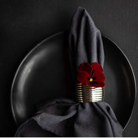 Spring table setting with red tricolor viola flower on dark wooden background with copy spaceの写真素材