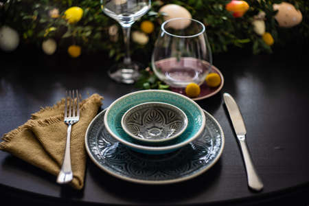 Festive table setting for Easter holiday dinner decorated with flowers and eggs