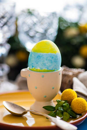 Festive table setting for Easter holiday dinner decorated with flowers and eggs